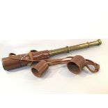 A brass three draw army telescope with leather mounted case, complete with eye and lens cover (fully