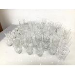 A large assortment of cut crystal and glass drinking glasses, all with a stylised palmette motif,