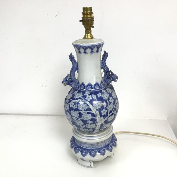 A blue and white Chinese table lamp, the baluster form body with dragon handles to side, on three