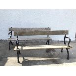 Two similar garden benches, with cast iron naturalistic supports and wooden seats and back rests (