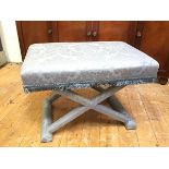 An X frame stool with blue floral upholstery with fringed apron and upholstered legs (46cm x 68cm