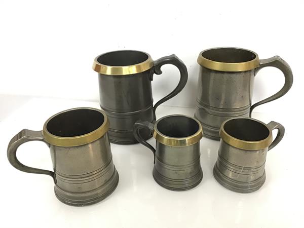 A group of pewter tankards, all with brass rims, including two Quarts, two pints and two half pints,