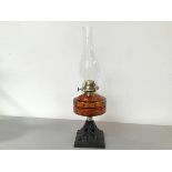 An Edwardian cast iron base oil lamp complete with amber glass oil well and clear glass funnel (49cm