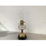 A Victorian brass oil lamp mounted on vitrolite style base, with clear glass well, complete with