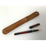 An Elysee fountain pen with red lava effect, complete with leather carry case (14cm)