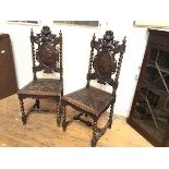 A pair of 19thc oak hall chairs, with surmounted plumed helmet and visor, with oval relief carved