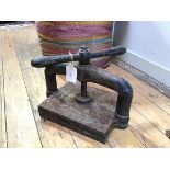 A 19thc cast iron book press, with turned spindle top, original paint distressed (32cm x 44cm x