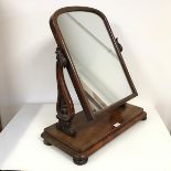 A Victorian mahogany dressing table mirror, the domed glass on hinged frame, on acanthus leaf