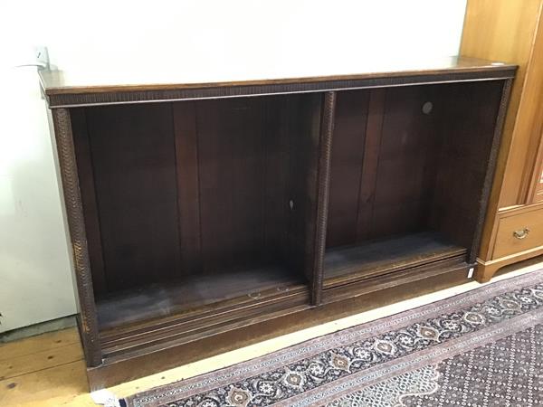 A 1920s oak open bookcase, with linenfold frieze, fitted five adjustable shelves, on plinth base (