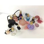 A collection of perfume atomisers of various designs, including Caithness blown glass, two black