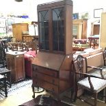 A 1920s bureau bookcase, the moulded top above a pair of glazed panel doors enclosing a shelved