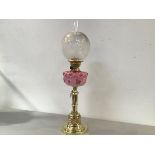 A Dimplex Victorian brass stepped column oil lamp with moulded overlaid glass pink poppy design