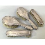 A Birmingham silver Edwardian four piece engine turned brush set, comprising two hairbrushes, and