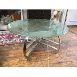 A 1980s occasional table, the circular glass top with swirl and bubbled texture, on a metal double X
