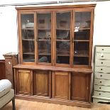 A handsome Edwardian mahogany bookcase, the moulded cornice above a walnut frieze, above two pairs