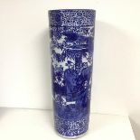 A Chinese umbrella stand in blue and white with figures in a woodland landscape (60cm x 21cm)