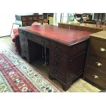 A reproduction mahogany twin pedestal kneehole desk, the top with inset skiver above a centre frieze