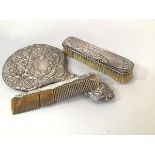 A Birmingham silver three piece associated dressing table brush set comprising winged cherub and C