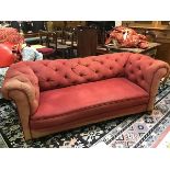 A 1920s Chesterfield drop end sofa with button back and scroll arms, upholstered in soft pink