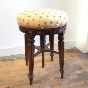 A William IV mahogany revolving rise and fall circular piano stool with gold and red designed