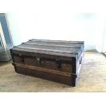 A late 19thc metal and oak bound rectangular travelling trunk with twin handles to side and faux