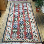 A kelim rug with three rows of hexagonal medallions within a geometric pattern border (216cm x