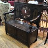 A 1920s oak hall bench, the plain top with centre canework circular panel flanked by arched