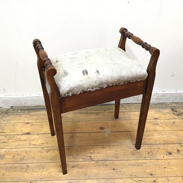 A 19thc stained birch piano stool, the hinged padded seat over a recessed interior, with turned