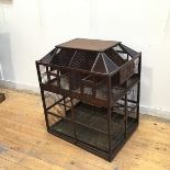 A large Victorian bird cage, the sarcophagus shaped top with coloured glass to corners over four