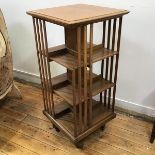 A mid 20thc oak revolving bookcase, with moulded square top above three shelves, on castors,