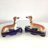 A pair of 19thc Staffordshire hound quill holders, decorated with polychrome enamels (10cm x 11cm