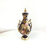 A Royal Crown Derby urn shaped two handled vase complete with cover, decorated with scrolling floral