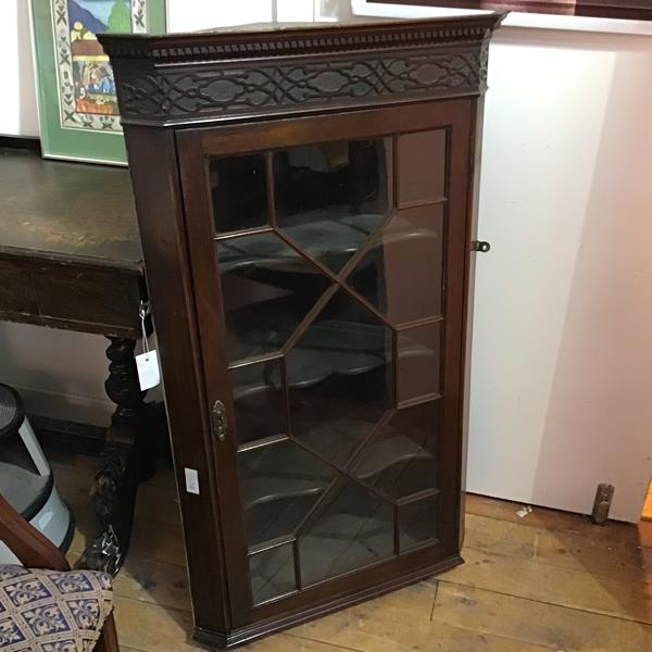 A 19thc mahogany wall corner cabinet, with dentil cornice and blind carved frieze, the glazed