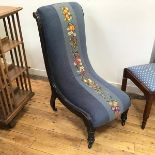 A late Victorian ebonised nursing chair with upholstered back and seat, with central fruit and