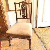 An Edwardian nursing chair, pressed with central rosette over pierced floral splat, with upholstered