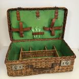 A Coracle wicker picnic basket, with hinged top and fitted interior, with leather straps for plates,