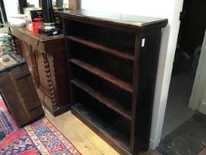 An Edwardian stained pine upright open bookcase fitted three adjustable shelves, raised on plinth