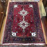 A North Persian rug, with twin central medallions within a foliate and stylised flowerhead border,