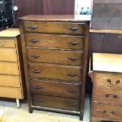 A Utility oak tallboy chest, the rectangular top with moulded edge above six graduated long drawers,