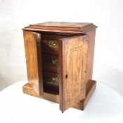 A Victorian walnut cabinet with nest of drawers, the inlaid top with moulded edge above a pair of