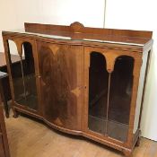 A 1930s bow fronted ledge back display cabinet, the top with moulded edge above a centre bow fronted