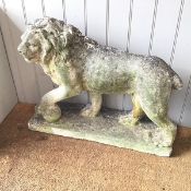 A composition stone lion figure, with paw raised on ball, on moulded base (59cm x base: 73cm x