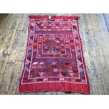 A kelim rug, with geometric and animal design, red field, areas of wear and tear, attached to slat