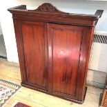 A mahogany Victorian hanging cabinet, with panelled doors and shelved interior with one glass