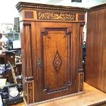 An early 19thc oak hanging cabinet, with bird and flower marquetry panels, with panelled door and