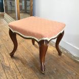 A 19thc walnut rectangular stool with upholstered peach and gold top, raised on carved moulded