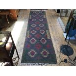 A kelim flatwoven hall runner, the centre panel with stylised flowerhead repeating design,