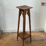 An Edwardian oak plant stand, the square top with moulded edge on splay square supports united by