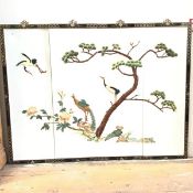 A Chinese four panel wall screen applied in coloured soapstone with birds and pine tree, in ebonised