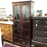 A reproduction mahogany Edwardian style upright bookcase, with moulded top above a pair of arched